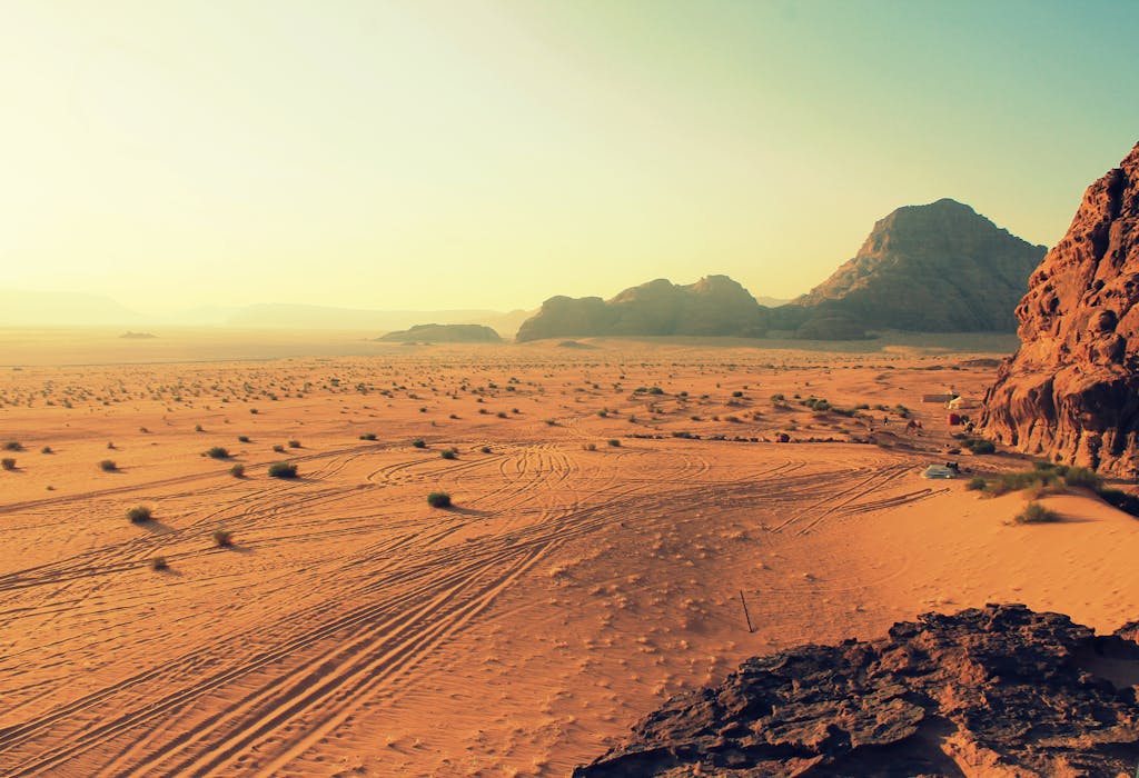 Explore the stunning beauty of Wadi Rum's arid desert landscape, bathed in warm sunset hues.